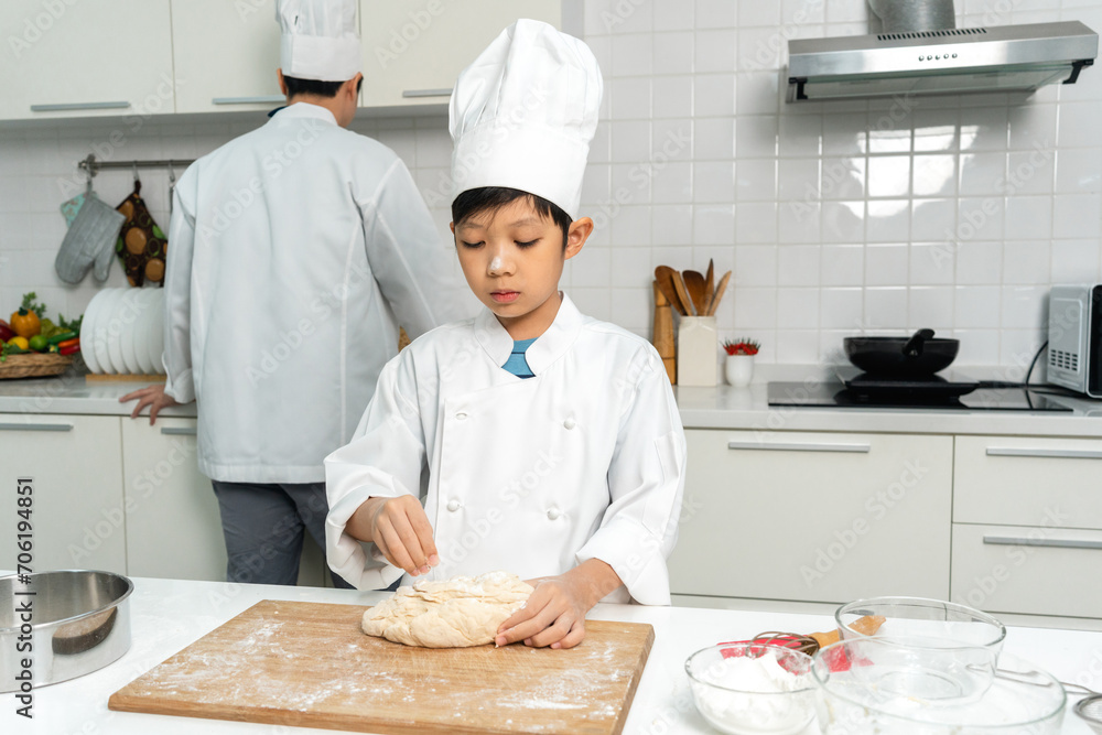Young handsome asian man chef cooking breakfast in the kitchen. Happy asian man preparing food with ingredient. Chef in uniform in the kitchen.