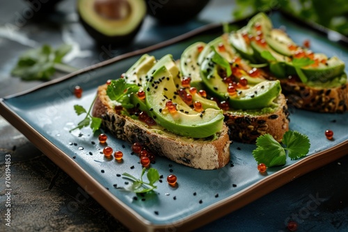  a blue plate topped with slices of bread covered in avocado and sprinkles of red pepper.