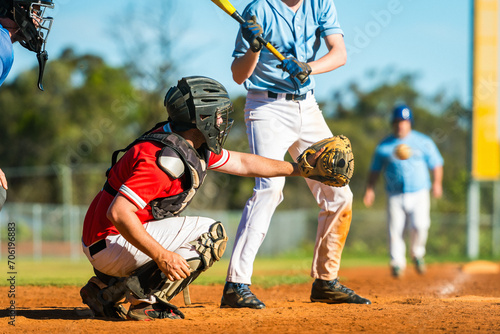 Men playing baseball game. Catcher is trying to catch a baseball during ballgame on a baseball diamond