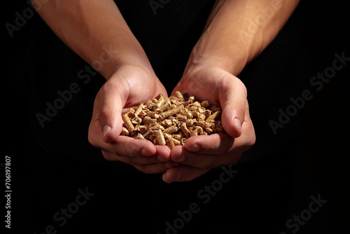 Human hands holding wooden pellets biofuel studio shot