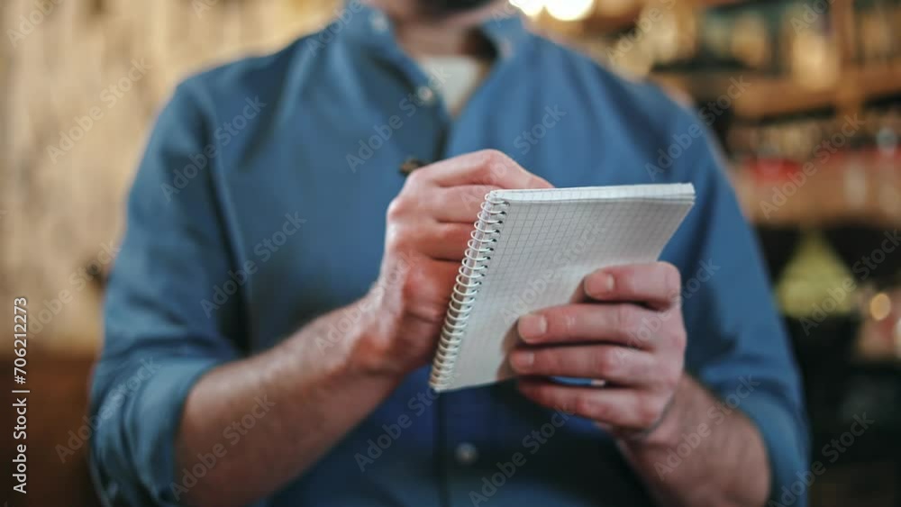 Close up of professional male waiter using pen and paper notepad for taking client order at restaurant. Caucasian man in uniform writing down all information while providing good customer service. Close up of professional male waiter using pen and paper notepad for taking client order at restaurant. Caucasian man in uniform writing down all information while providing good customer service.