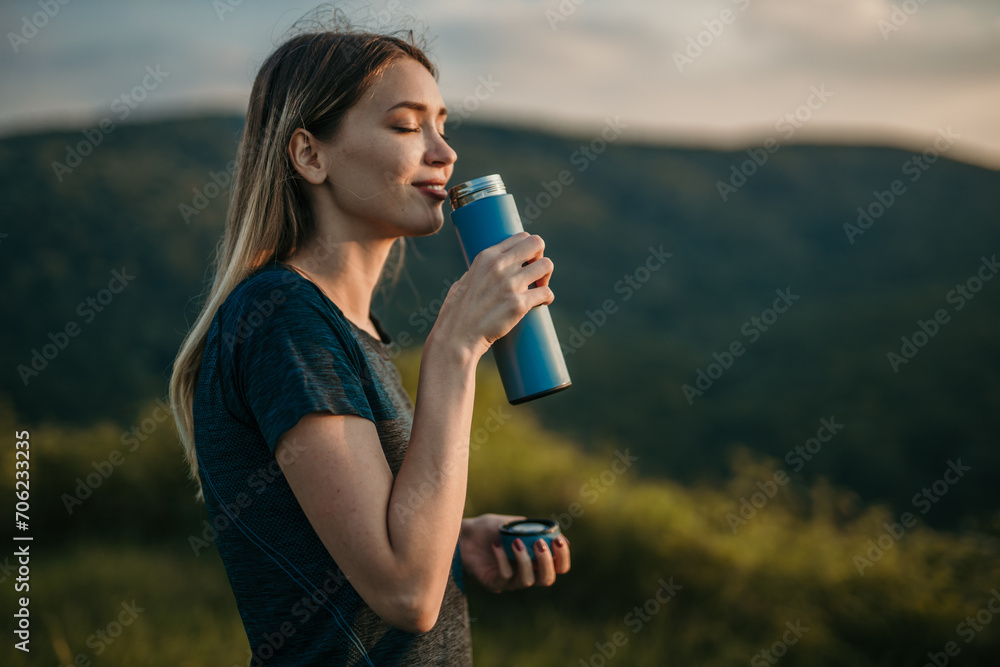 Fit Caucasian woman quenching her thirst with refreshing water after a vigorous outdoor jog Fit Caucasian woman quenching her thirst with refreshing water after a vigorous outdoor jog