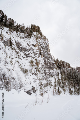 A high cliff over the river covered with snow, a winter landscape, a beautiful rock, taiga in the north of the country, remote remote places. © Aleksey
