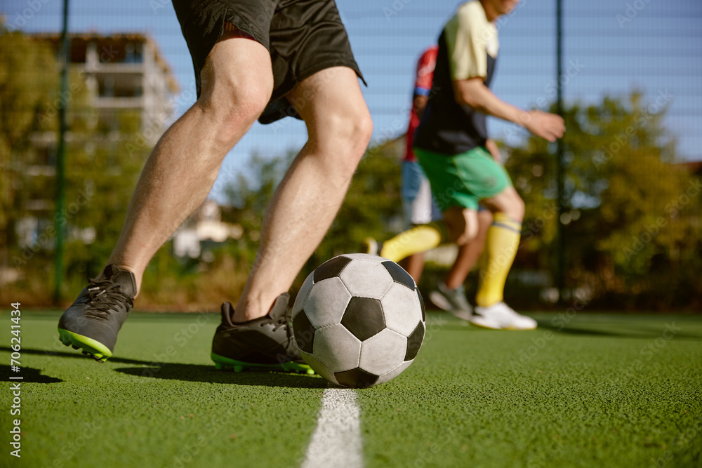 Soccer player kicking ball cropped shot, amateur football match