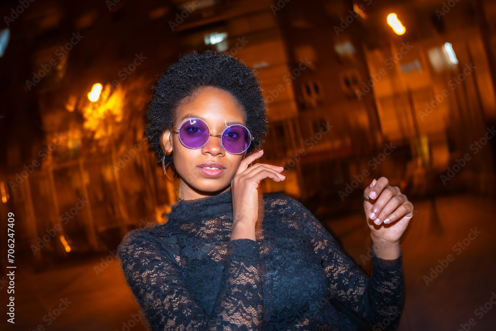 Fashionable african woman dancing in the street at night Fashionable african woman dancing in the street at night