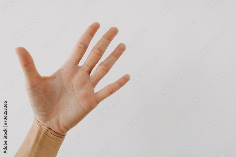 Photo of woman's hand showing numbers five, woman palm counting fingers gesture, isolated on white background wall.