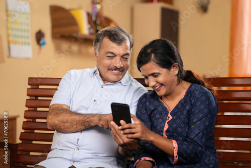 Sticker 50s Indian father showing proposal photos on mobile phone to daughter for marria