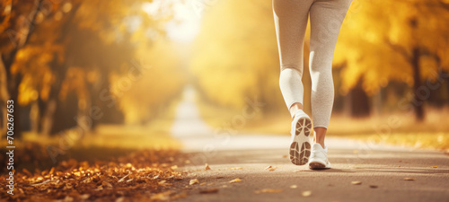 Fit woman walking in park during autumn time, athlete's foots close-up  in nature outdoors, healthy lifestyle and sport concepts. photo