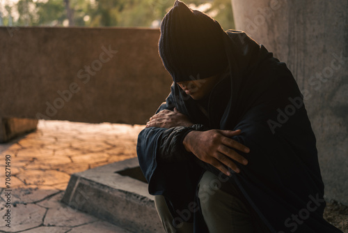 Homeless man on the street waiting for help food and money from people volunteer foundation donate. Poor tired stressed depressed hungry homeless man