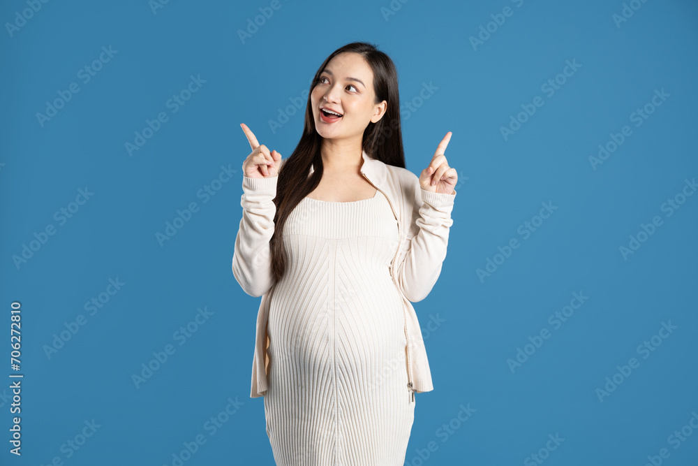 Portrait of pregnant asian woman, isolated on blue background Portrait of pregnant asian woman, isolated on blue background