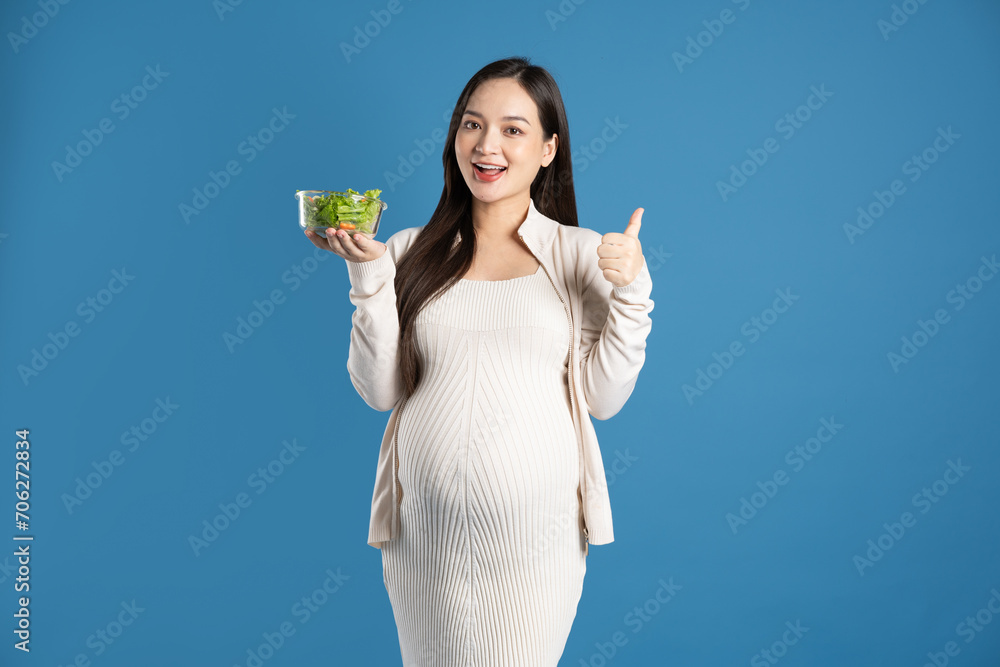 Portrait of pregnant asian woman, isolated on blue background Portrait of pregnant asian woman, isolated on blue background