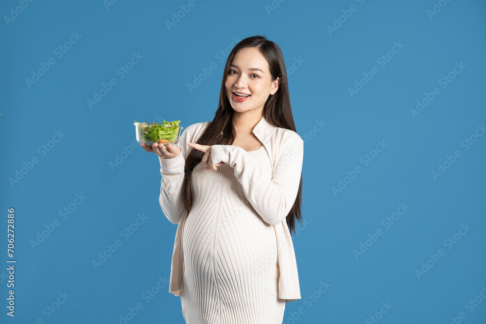 Portrait of pregnant asian woman, isolated on blue background