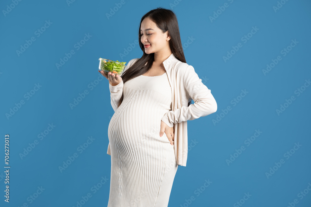 Portrait of pregnant asian woman, isolated on blue background Portrait of pregnant asian woman, isolated on blue background