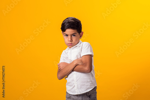 Upset kid boy over yellow background. Emotions and bulling concept