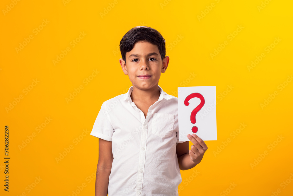Kid boy holding question mark card in hand. Education concept