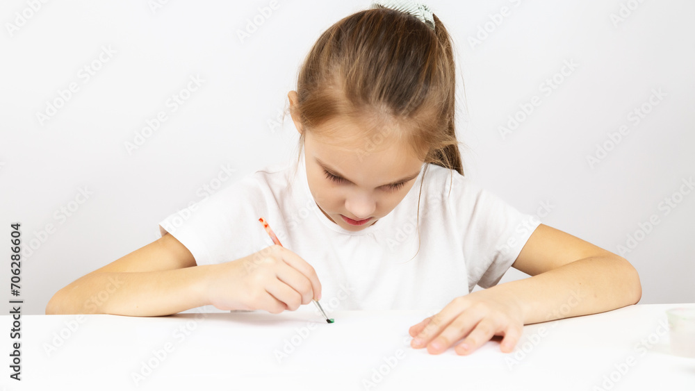 Caucasian child girl painting at table indoors Caucasian child girl painting at table indoors