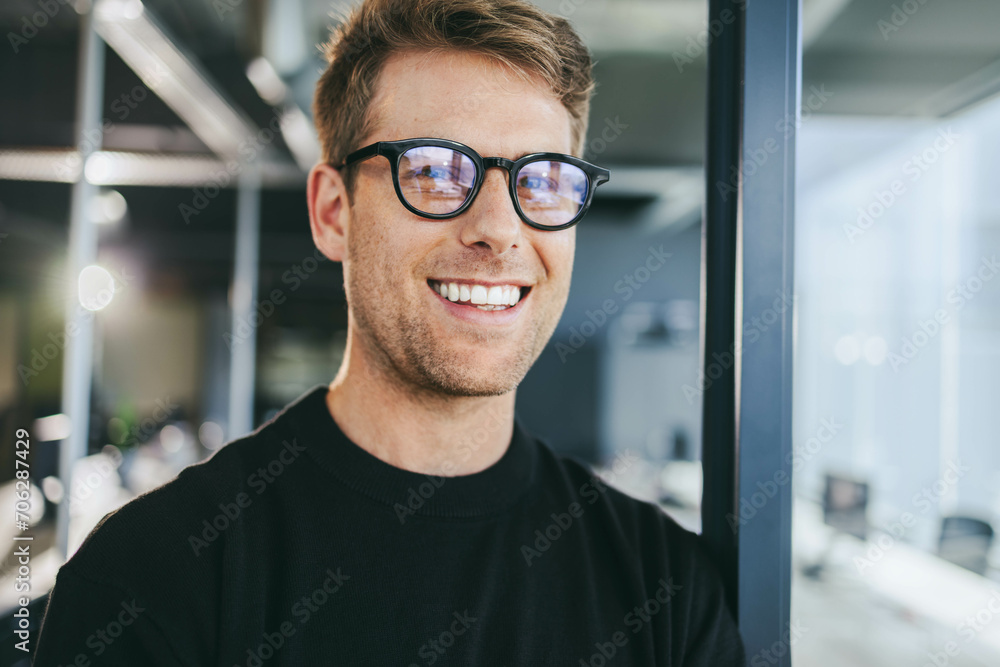 Confident professional in office environment smiling at camera Confident professional in office environment smiling at camera