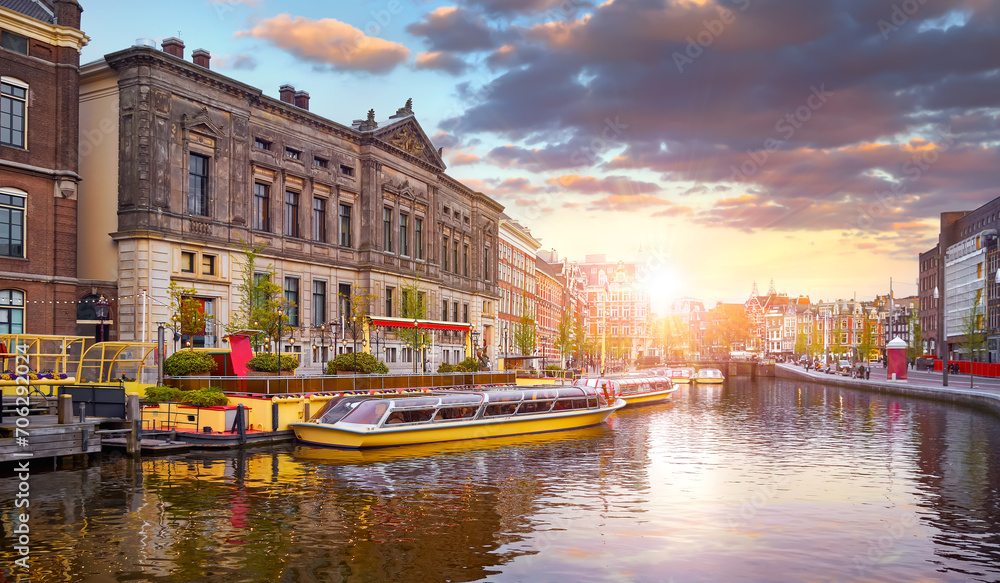 Amsterdam, Holland, Netherlands. Amstel river, canals and boats against evening dusk sunset sky cityscape. Pleasure of amsterdam for touristic tours entertainment travel