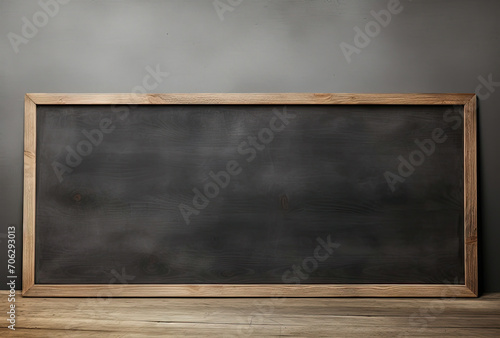 Blackboard on Wooden Floor in Front of Gray Wall - Educational Concept