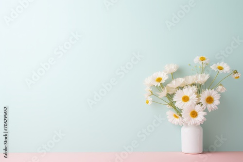 White daisies in a modern white vase on a pastel pink surface, with ample copy space for a serene message