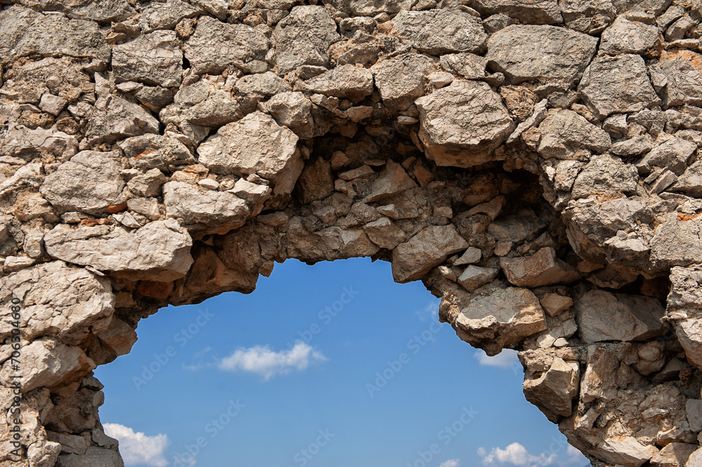 Ancient brick old stones wall arch with the sky as the background