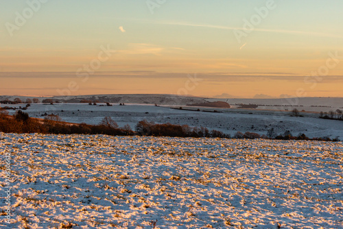 Snow covering fields on Ditchling Beacon in the South Downs, with a sunset sky overhead