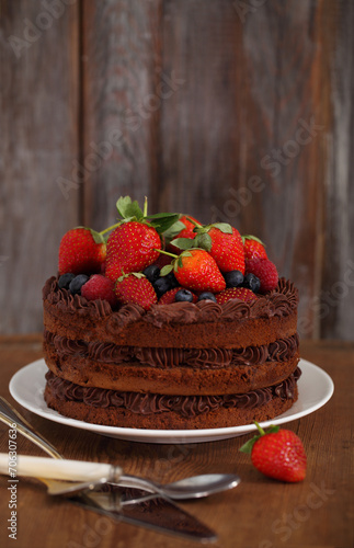 Chocolate cake with icing and fresh berry