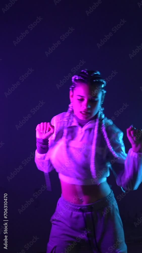 Rap dancer with white braids dancing with neon lights against, head and shoulder movements in blue and pink light Rap dancer with white braids dancing with neon lights against, head and shoulder movements in blue and pink light