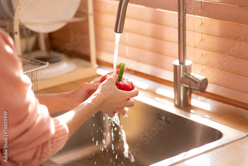 Asian healthy woman washing  vegetable and other fruit above kitchen sink and cleaning. photo