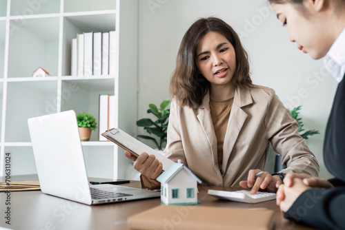 Real estate agent talk to new homebuyers and offer good interest rates and calculate clients on mortgage finance