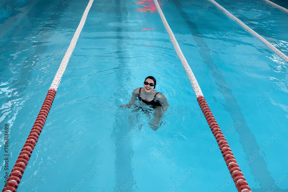 Portrait of a fit woman catcher in the pool looking to the camera
