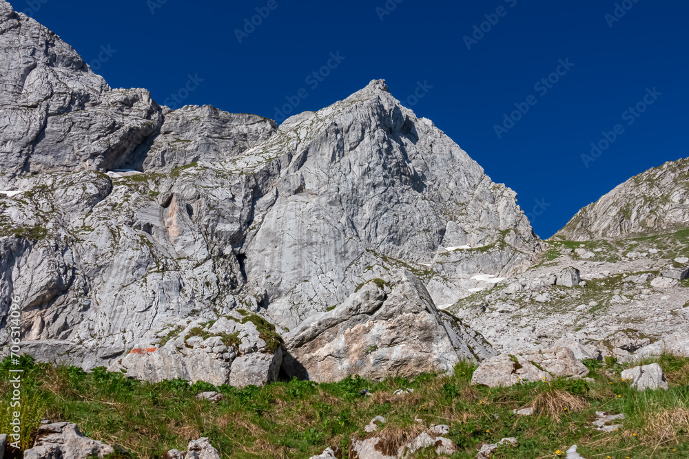Scenic hiking trail from Fusine Lake to Mangart saddle in Tarvisio, Julian Alps, Friuli Venezia Giulia, Italy, Europe. Rugged mountain rock formations on extreme alpine terrain in summer. Wanderlust Scenic hiking trail from Fusine Lake to Mangart saddle in Tarvisio, Julian Alps, Friuli Venezia Giulia, Italy, Europe. Rugged mountain rock formations on extreme alpine terrain in summer. Wanderlust