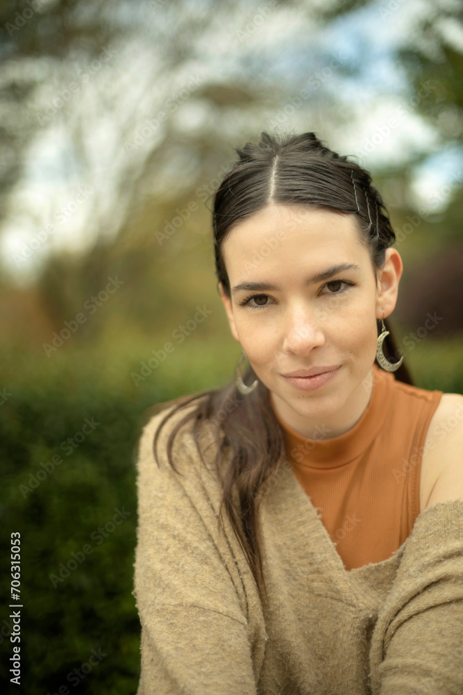 Vertical photo. Outdoor closeup of young Caucasian model woman with natural beauty and well-being expression looking at camera Vertical photo. Outdoor closeup of young Caucasian model woman with natural beauty and well-being expression looking at camera