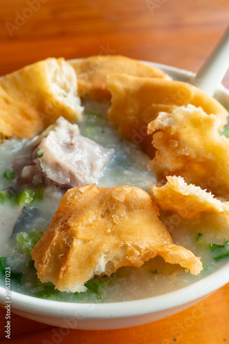 angle view fish porridge with deep-fried Chinese donuts at vertical composition