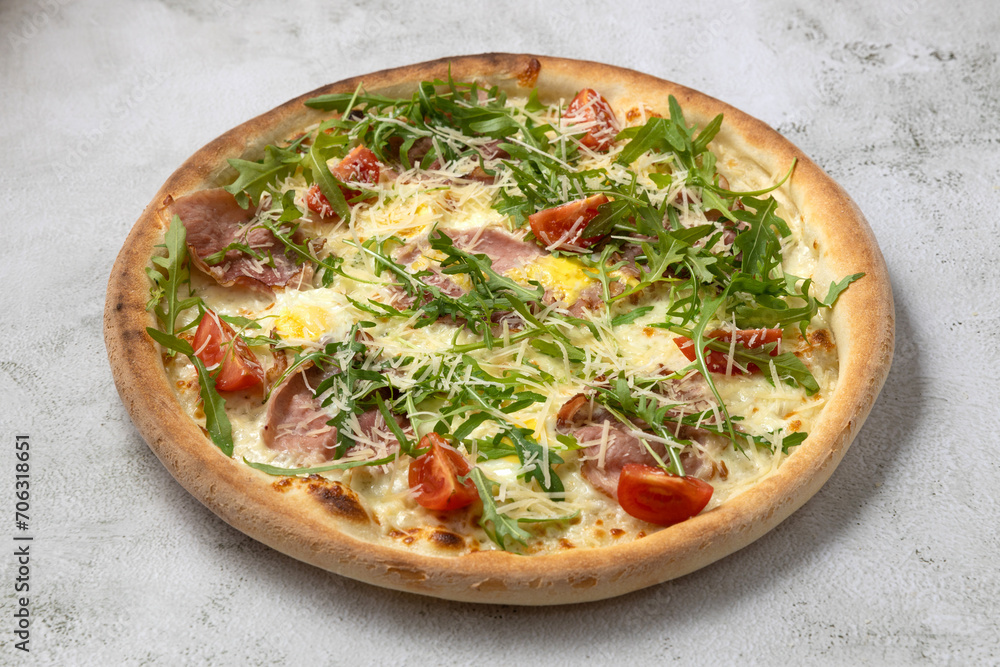 Tasty italian pizza with arugula,cherry tomatoes,egg,bacon.Isolated on gray background Tasty italian pizza with arugula,cherry tomatoes,egg,bacon.Isolated on gray background