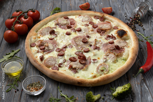 Delicious pizza with sousage on a wooden background photo