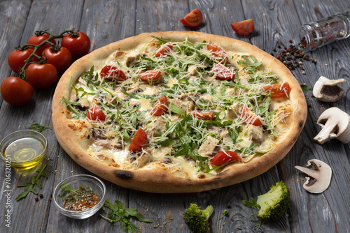 Appetizing italian pizza with cherry tomatoes, arugula, chicken breast.Italy food