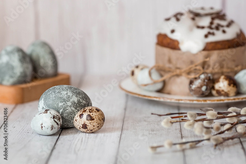 Stylish grey Easter eggs in the color of marble, concrete, willow branches and Easter cake on a white wooden background. Coloring eggs with natural dye karkade tea.  The feast of bright Easter.