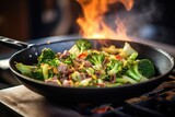 close-up of beef and broccoli stir-fry in a wok on high flame