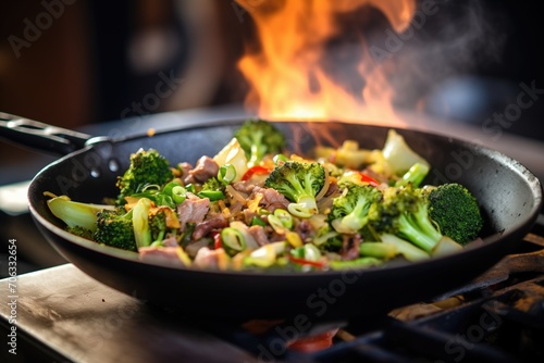 close-up of beef and broccoli stir-fry in a wok on high flame