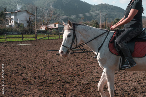 outdoors activity concept equestrian sport, woman riding white horse on village farm photo