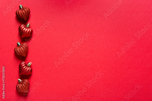 Valentines day card mockup with five voluminous small shiny hearts on red paper background, top view, copy space	