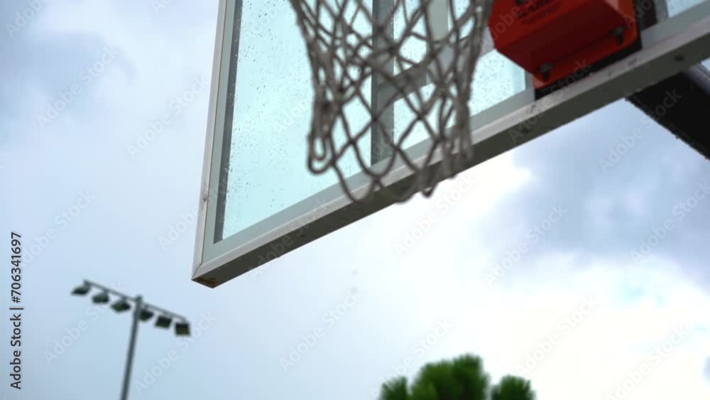 Dripping wet basketball backboard after heavy rainfall on city playground Dripping wet basketball backboard after heavy rainfall on city playground