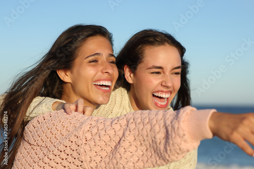 Fotografija Happy friends laughing hilariously pointing away