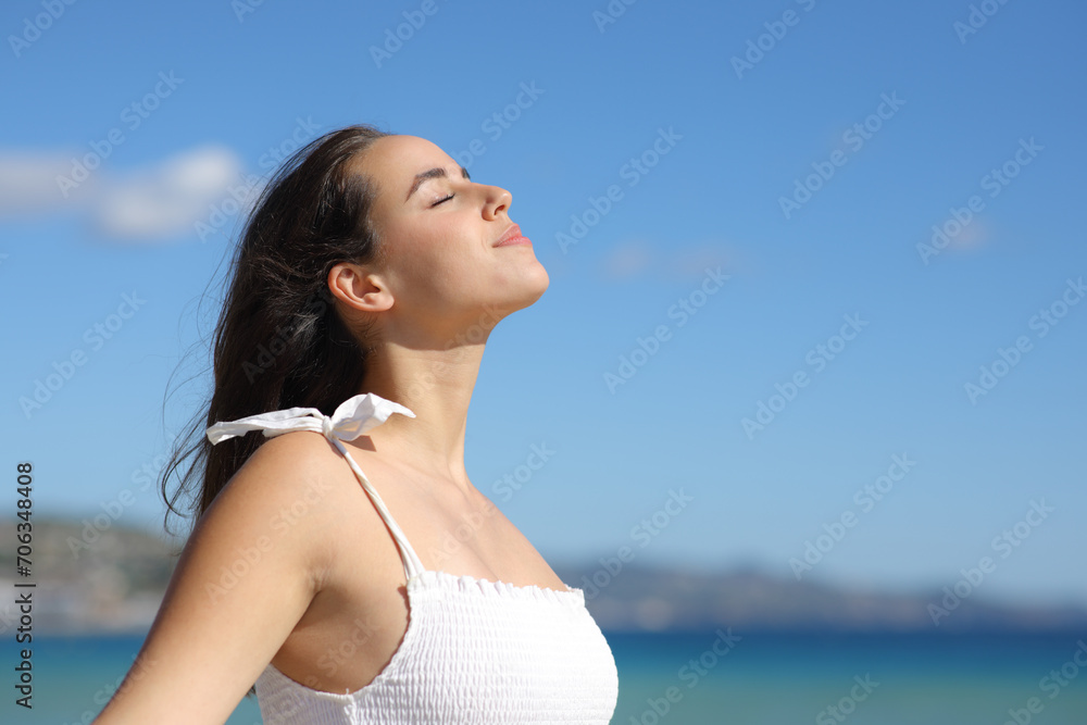 Relaxed woman in white dress breathing fresh air on the beach Relaxed woman in white dress breathing fresh air on the beach