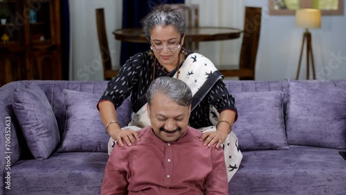 A retired old lady / a caring housewife is massaging tired husband's shoulders - massage . Body massage in old age - strong bones  body ache  home therapy  old routine  dadi ma ke nuskhe  caring fa... photo