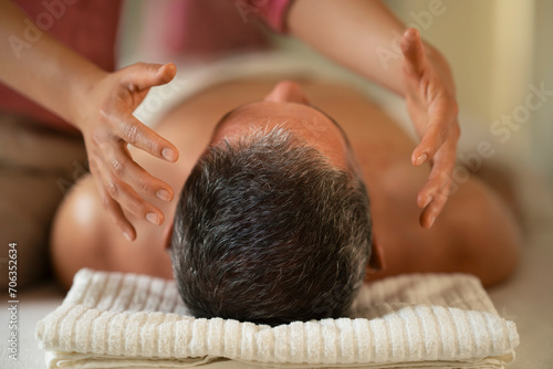 Man receiving energy medicine head massage in spa
 photo