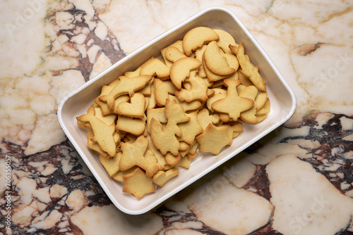 View from above sugar cookies in variety of shapes in dish on marble counter
 photo