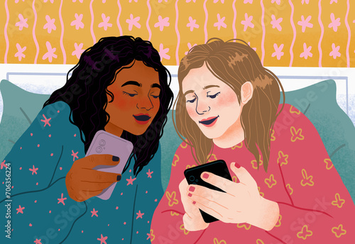 Teenage girl friends using smart phones and talking, enjoying sleepover
