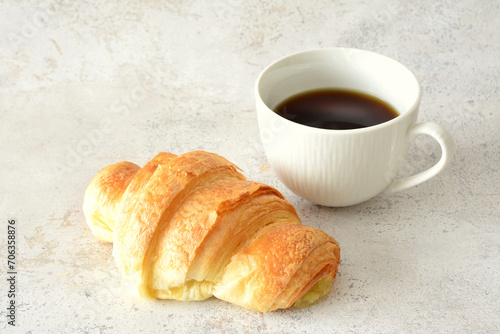 croissant with cup of hot coffee isolated close up